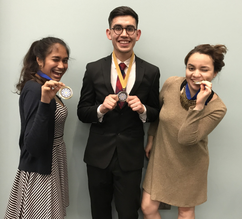 Three students celebrate with medals around their necks