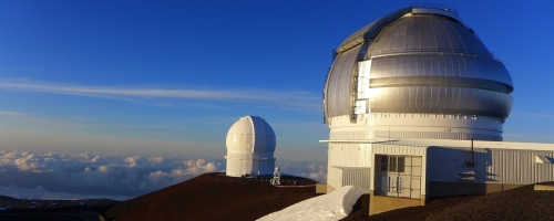 Two observatories at the top of Mount Kea above the clouds.