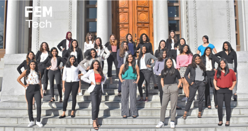 Twenty-eight females in tech members standing on the steps of a building and smiling for a group photo.